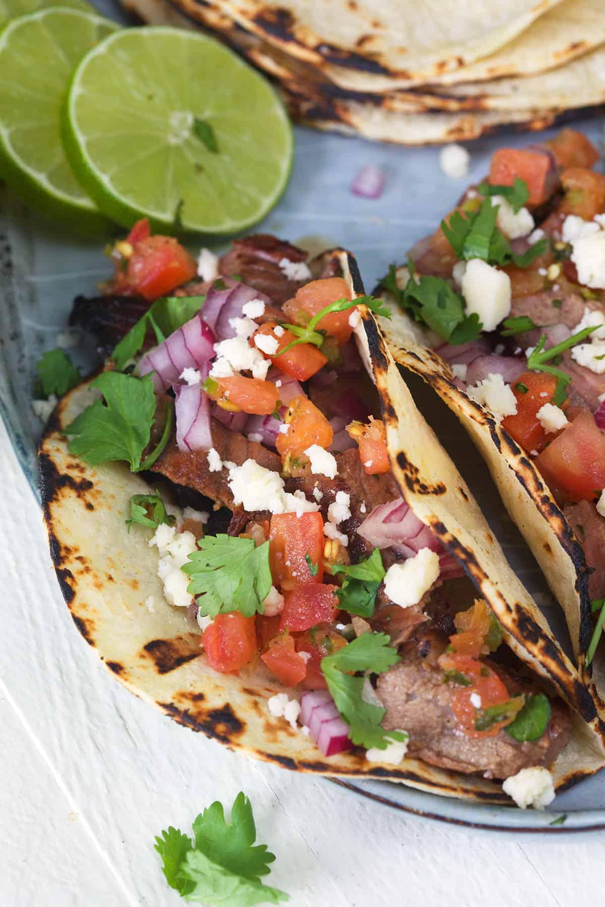 Semplici Tacos di Carne Asada 2 Due tacos di carne asada sono guarniti con coriandolo fresco, pico de gallo e formaggio cojita.