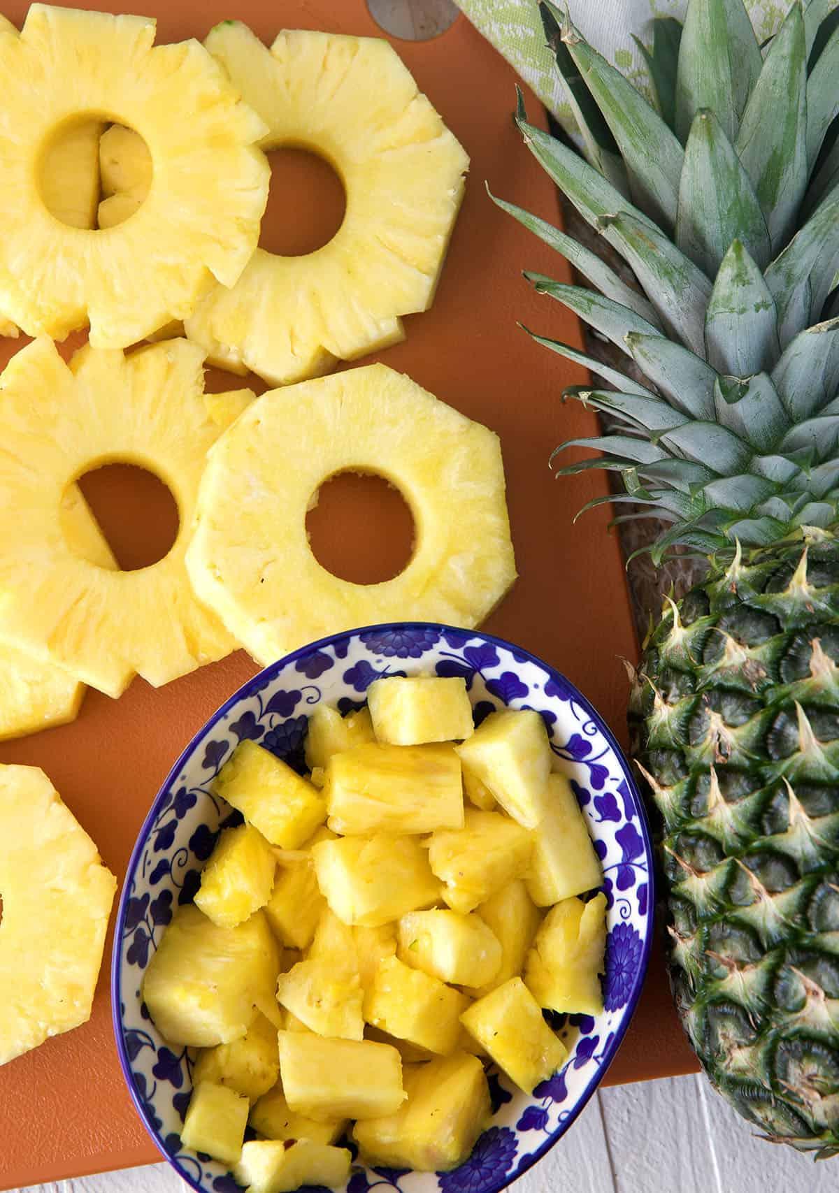 Come Tagliare un Ananas 2 Ananas tagliato a fette e a cubetti, accanto a un ananas intero.