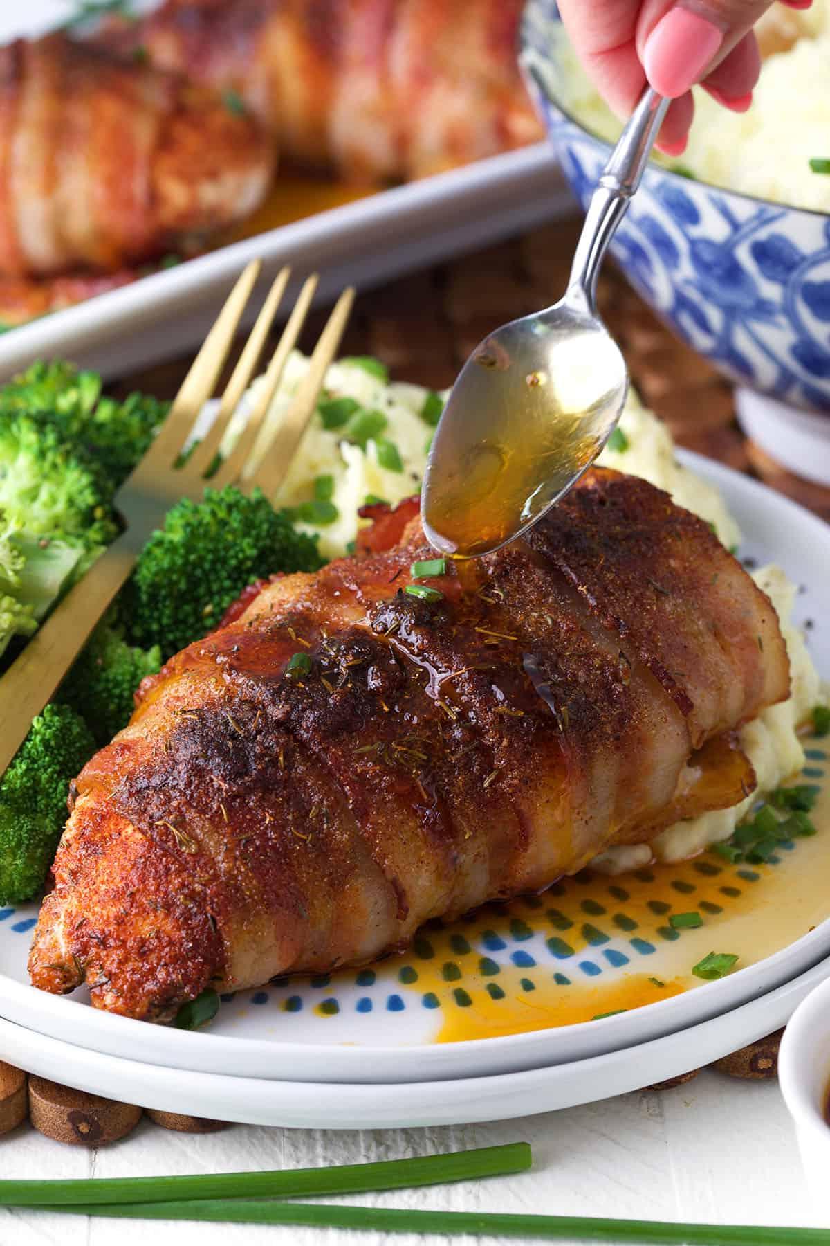 Petto di Pollo Avvolto nel Bacon 2 Un petto di pollo avvolto nella pancetta viene irrorato con il fondo di cottura.