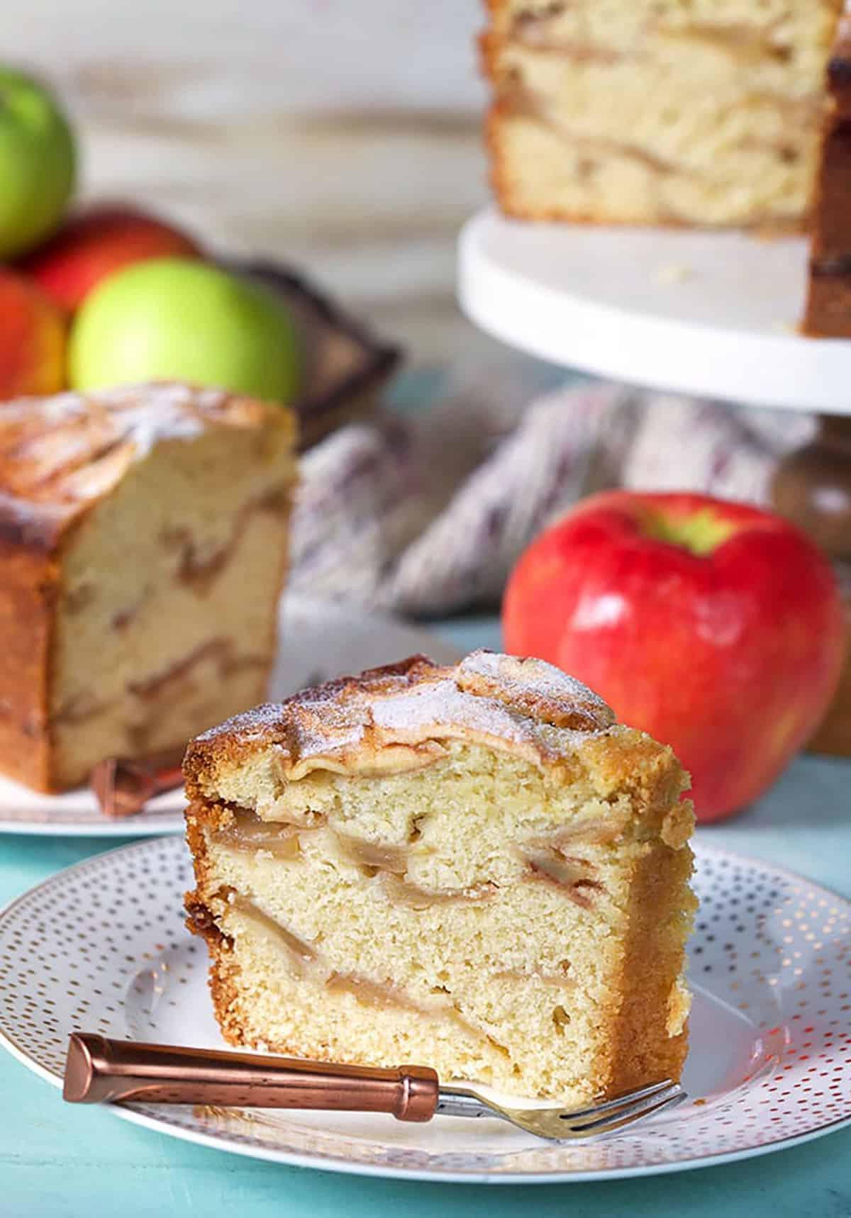 Torta di Mele Ebraica 2 Fetta di Torta di Mele Ebraica su un piatto bianco con una forchetta color rame.