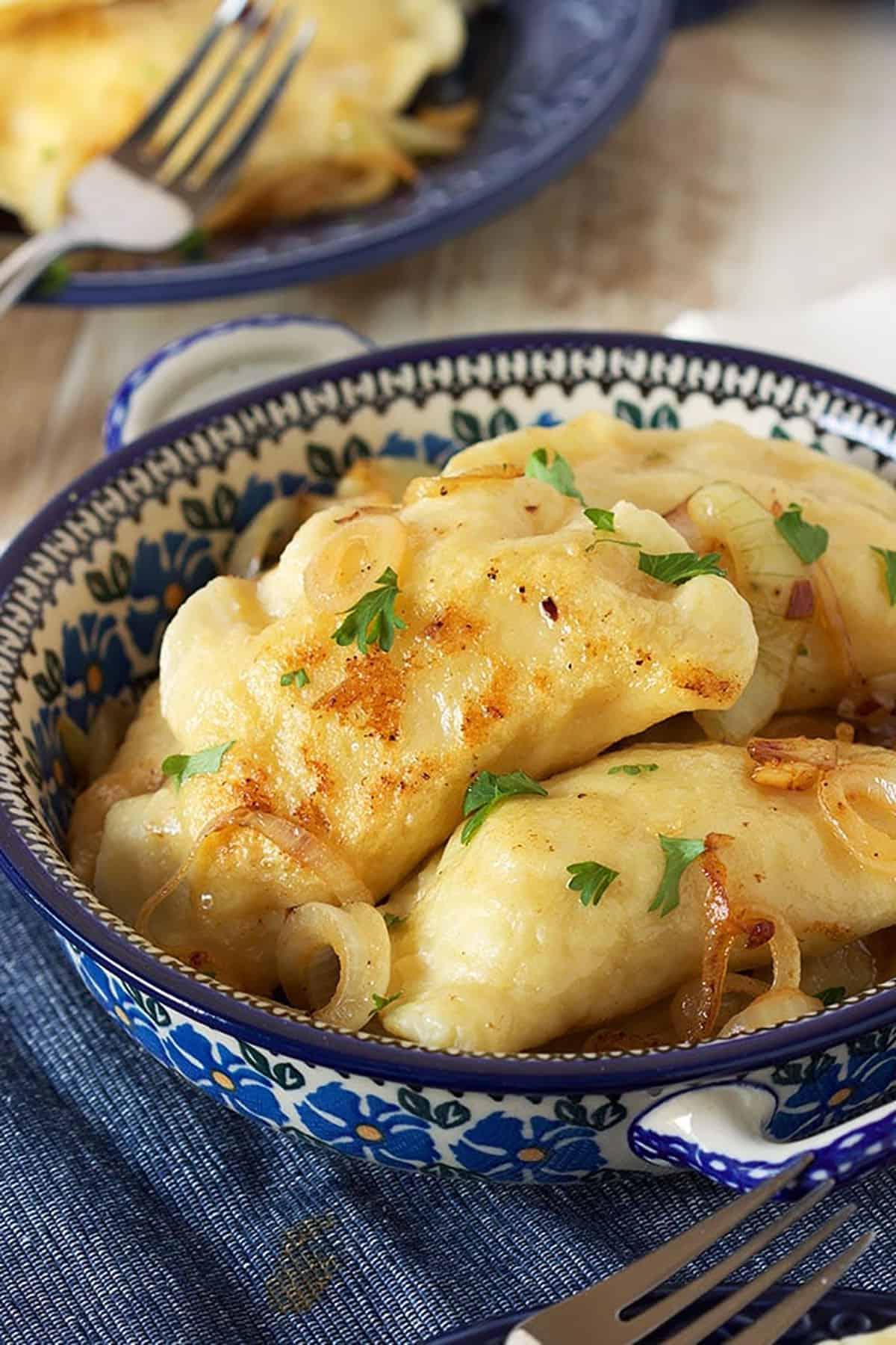 La migliore ricetta di pierogi di patate 2 Pierogi polacchi di patate in una pirofila di ceramica polacca.