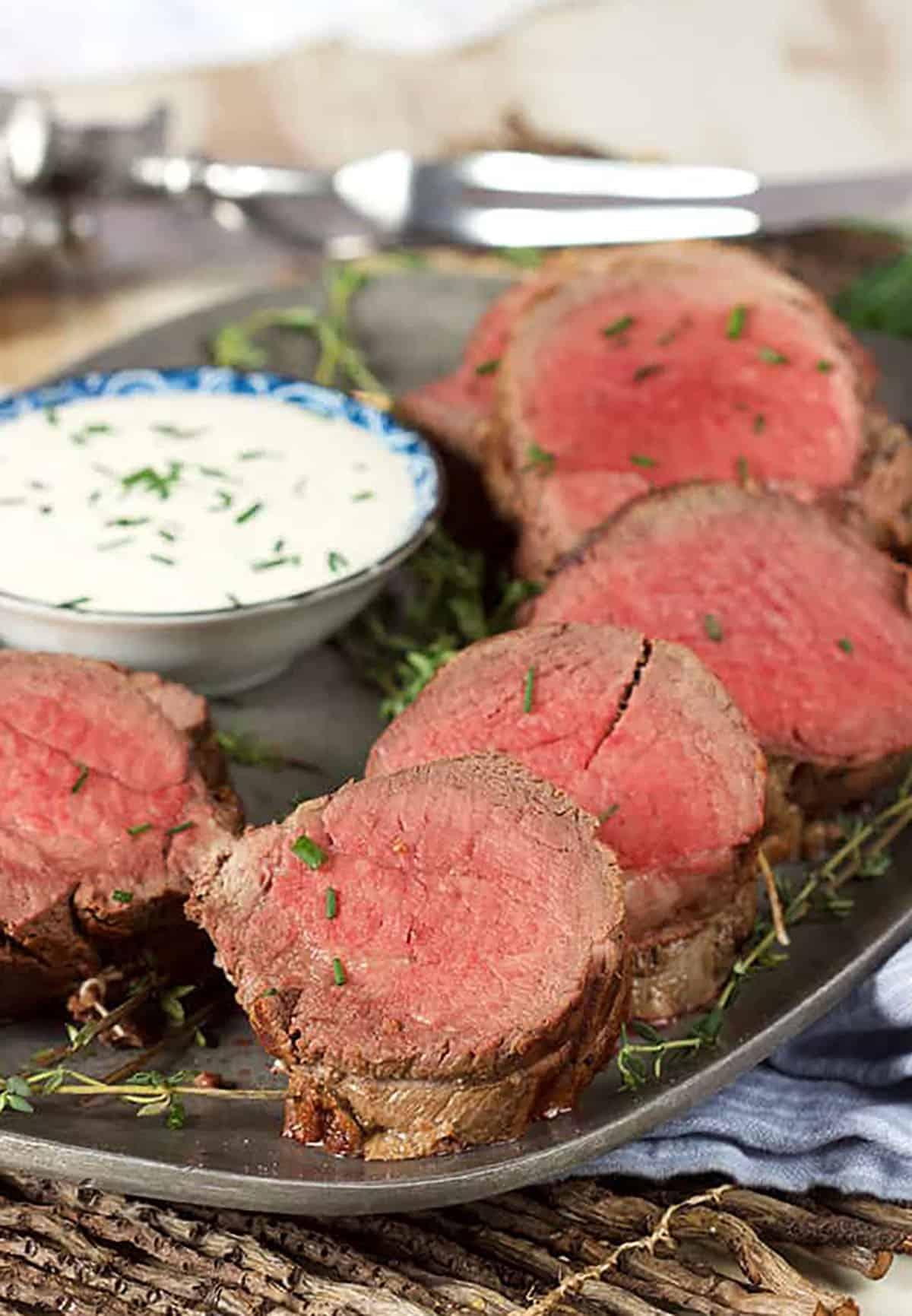 Arrosto Semplice di Filetto di Manzo 2 Filetto di manzo affettato su un piatto di peltro con una ciotola di salsa al rafano.