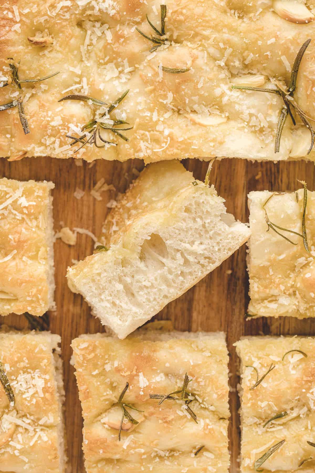 Focaccia all'Aglio e Rosmarino 2 Fette di focaccia sono posizionate su un tagliere di legno.
