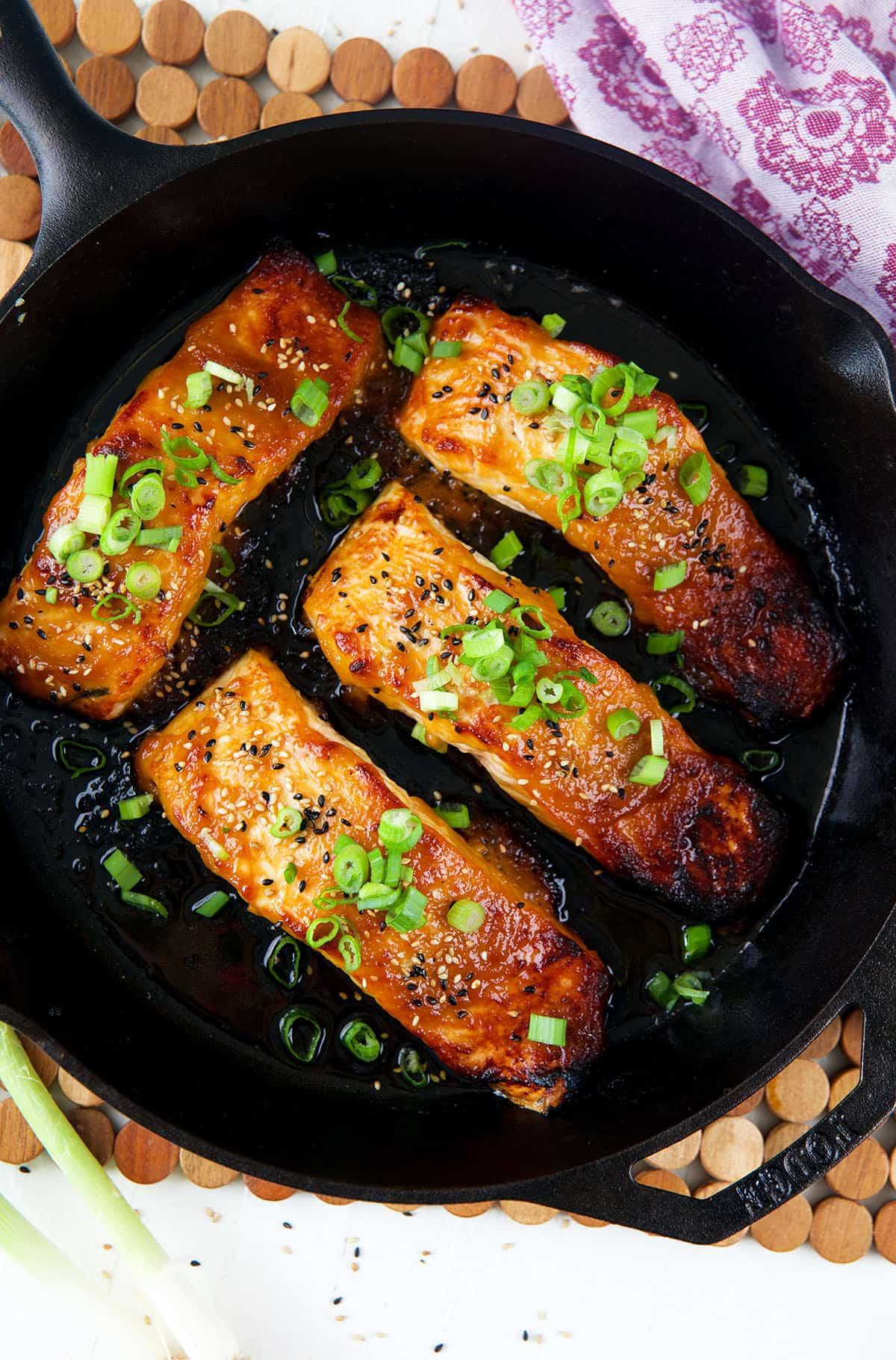 Salmone Glassato al Miso 2 Una padella contiene filetti di salmone perfettamente cotti e glassati.