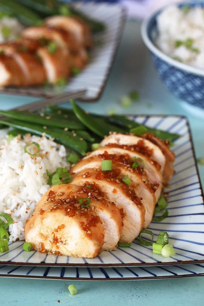 Le migliori ricette di petto di pollo al forno 14 Pollo teriyaki affettato su un piatto quadrato con riso bianco.