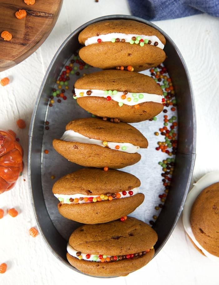 **Whoopie Pies alla Zucca con Ripieno al Mascarpone d'Acero** 3 Foto dall'alto di whoopie pies alla zucca disposti su un vassoio ovale in acciaio.