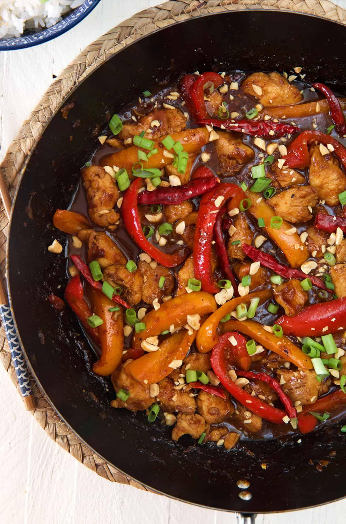 Pollo Kung Pao Facile 3 Una padella nera è piena di pollo Kung Pao cotto.