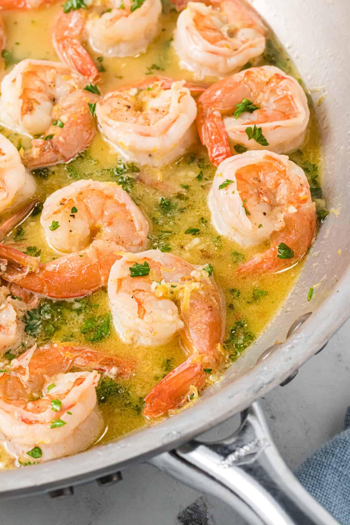 Gamberi Scampi 3 I gamberi vengono cotti in una salsa burrosa in una padella d'argento.