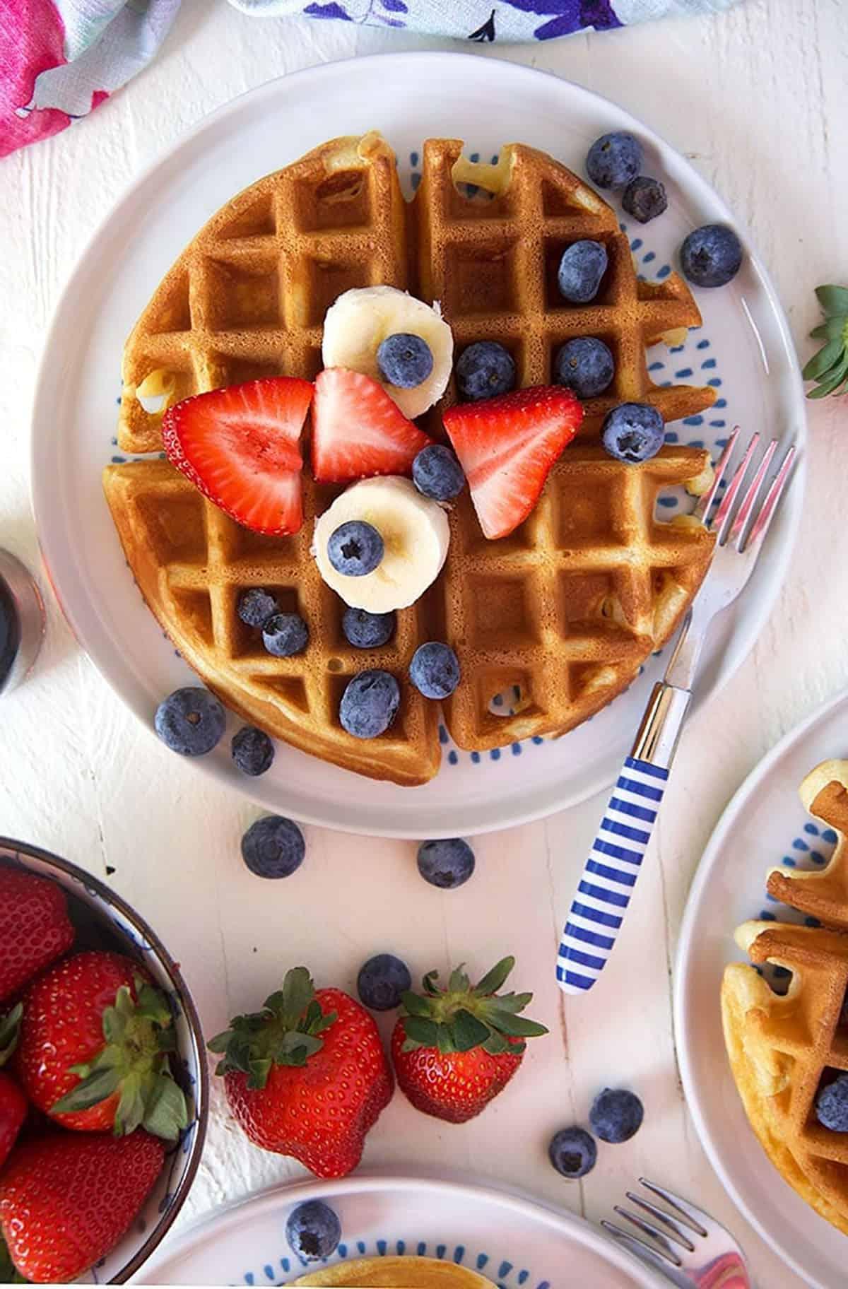 Il Migliore Waffle Belga Casalingo 3 Waffle belga con frutta fresca su un piatto bianco.