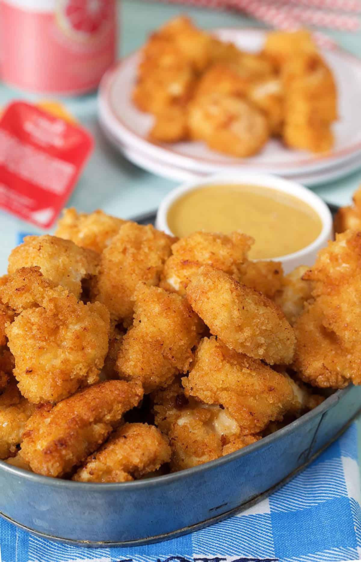 **Nuggets Imitazione Chick-fil-A** 3 Nuggets di pollo in una teglia d'acciaio con salsa.
