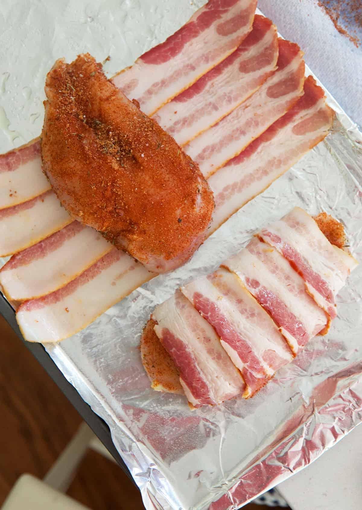 Petto di Pollo Avvolto nel Bacon 3 Un petto di pollo condito è posizionato al centro delle fette di pancetta.