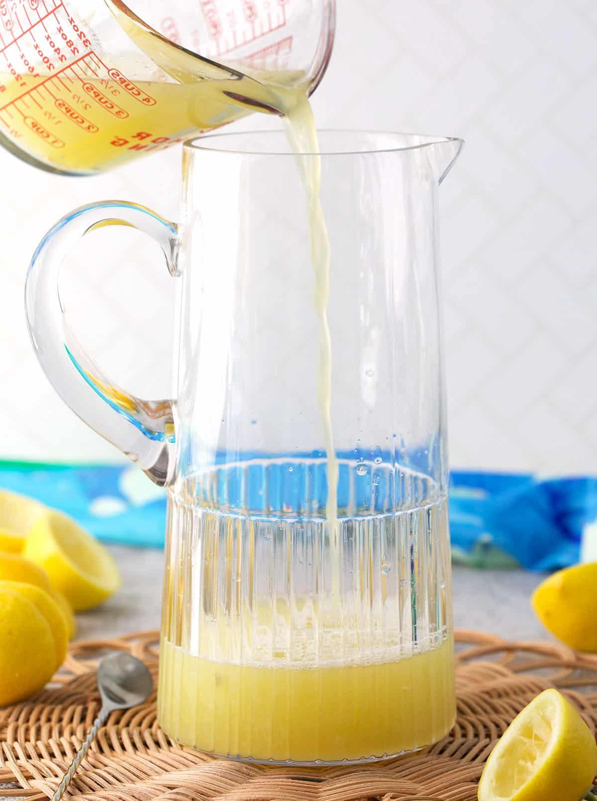 Ricetta della Limonata Fatta in Casa 4 Succo di limone versato in una caraffa di vetro.