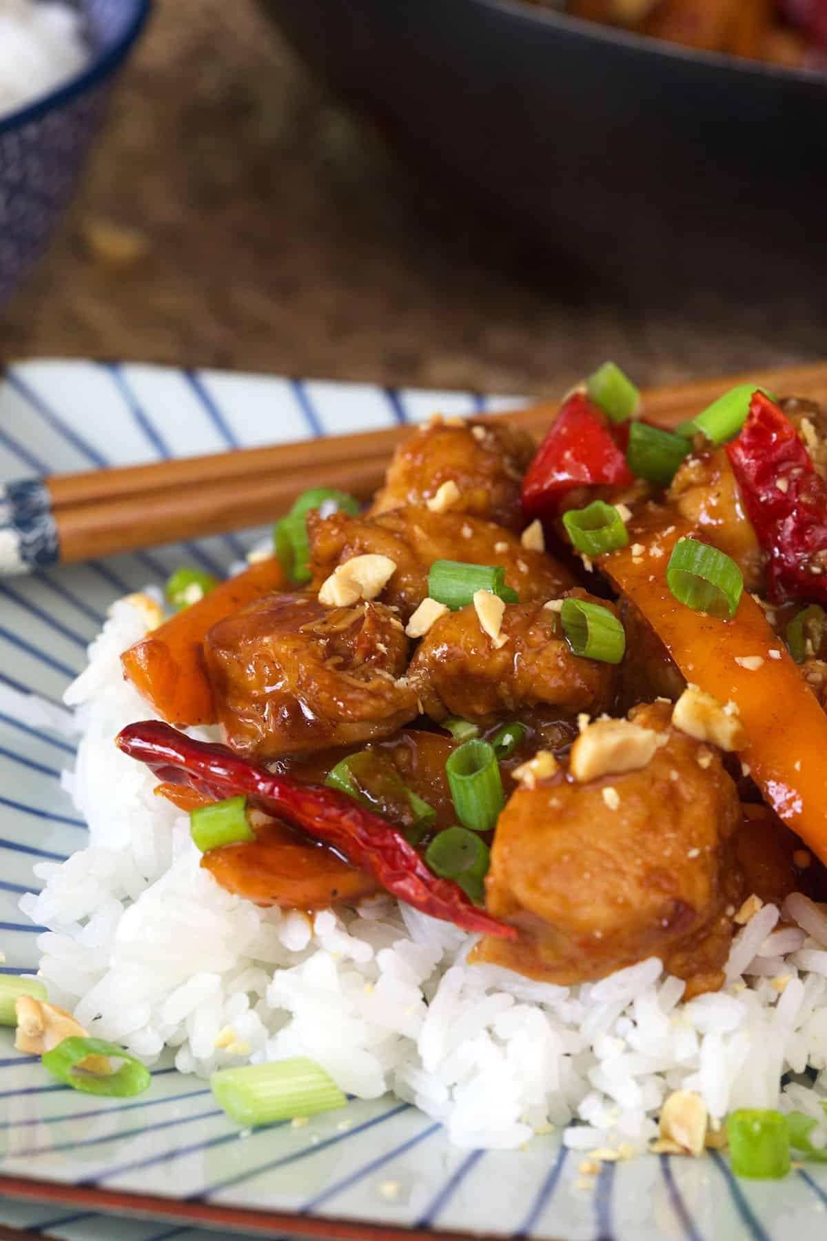 Pollo Kung Pao Facile 4 Un mucchio di pollo Kung Pao è impilato su una soffice porzione di riso bianco.