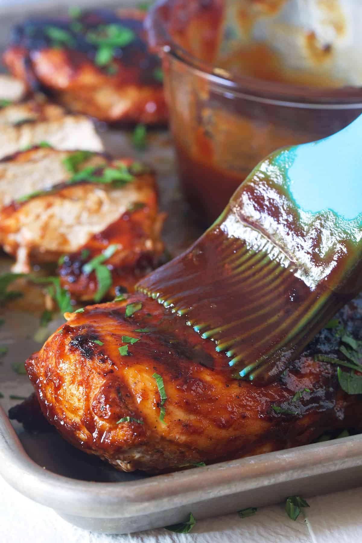 Petti di Pollo alla Griglia 4 La salsa BBQ viene spennellata su un petto di pollo.