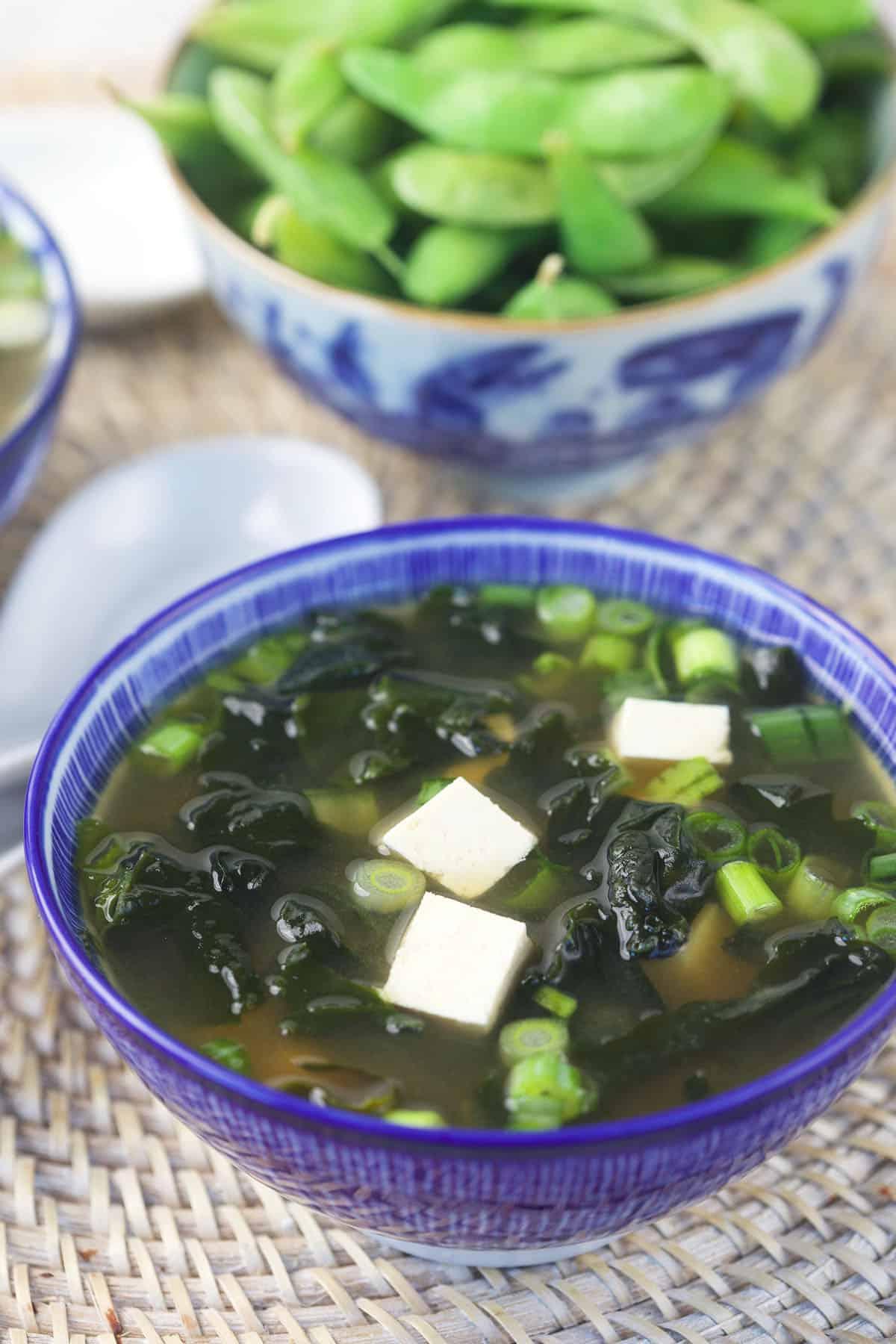 Zuppa di Miso Veloce e Facile 4 Una porzione di zuppa di miso è presentata elegantemente in una ciotola blu profonda.