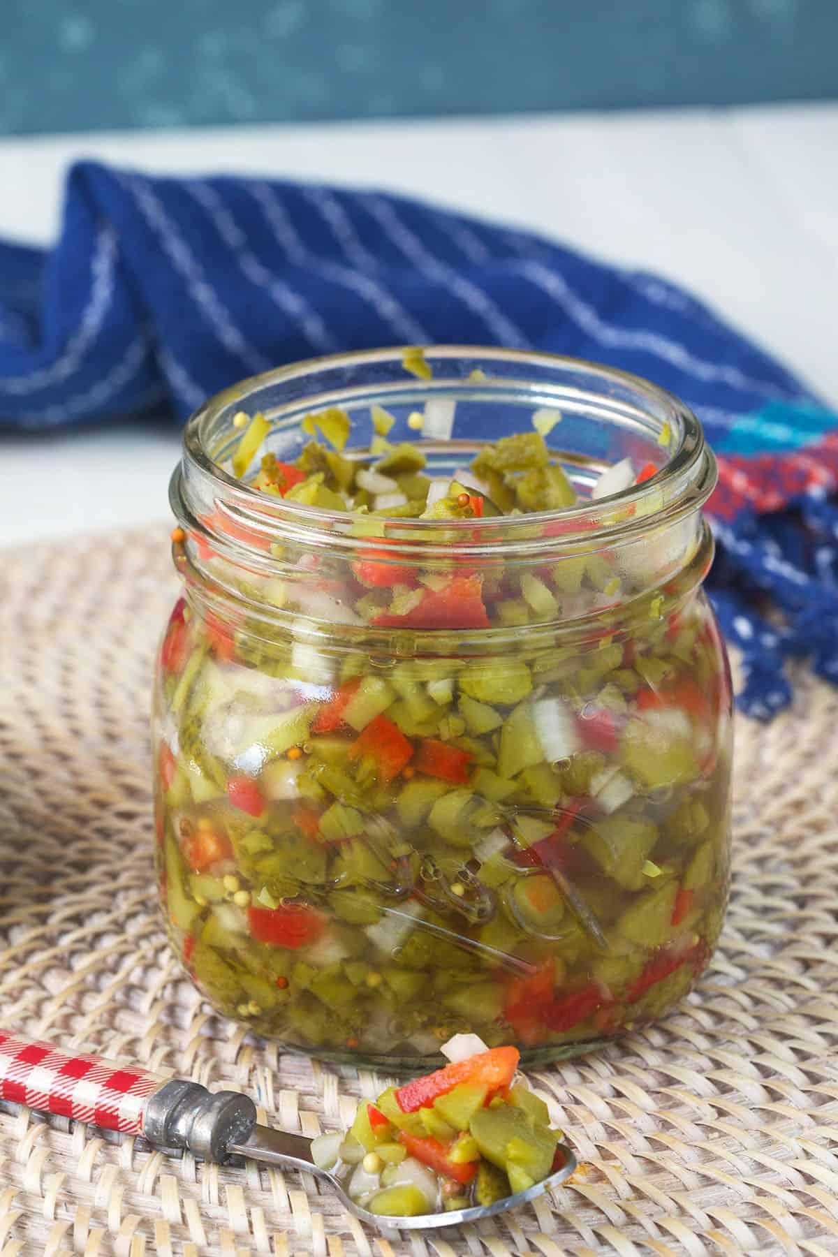 Salsa di Sottaceti Fatta in Casa 4 Un cucchiaio è posizionato accanto a un barattolo pieno di relish.