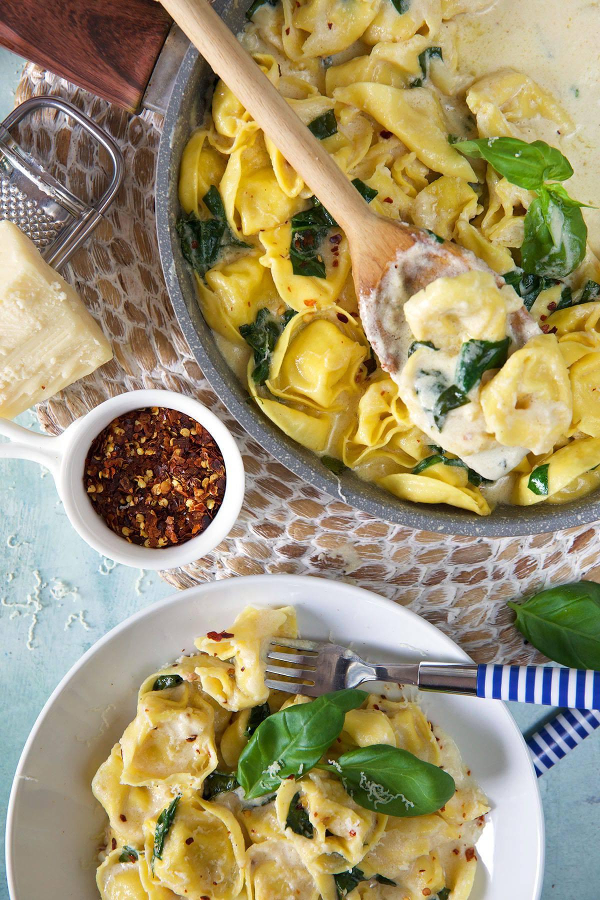 Tortellini all'Asiago 4 Un piatto di tortellini all'Asiago è posizionato accanto a una casseruola piena e pronta per essere servita.