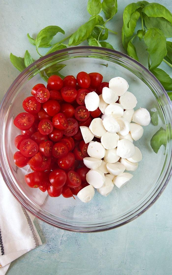 Insalata di Pomodoro e Mozzarella 4 Insalata di mozzarella e pomodorini in una ciotola su sfondo blu, prima di essere condita.