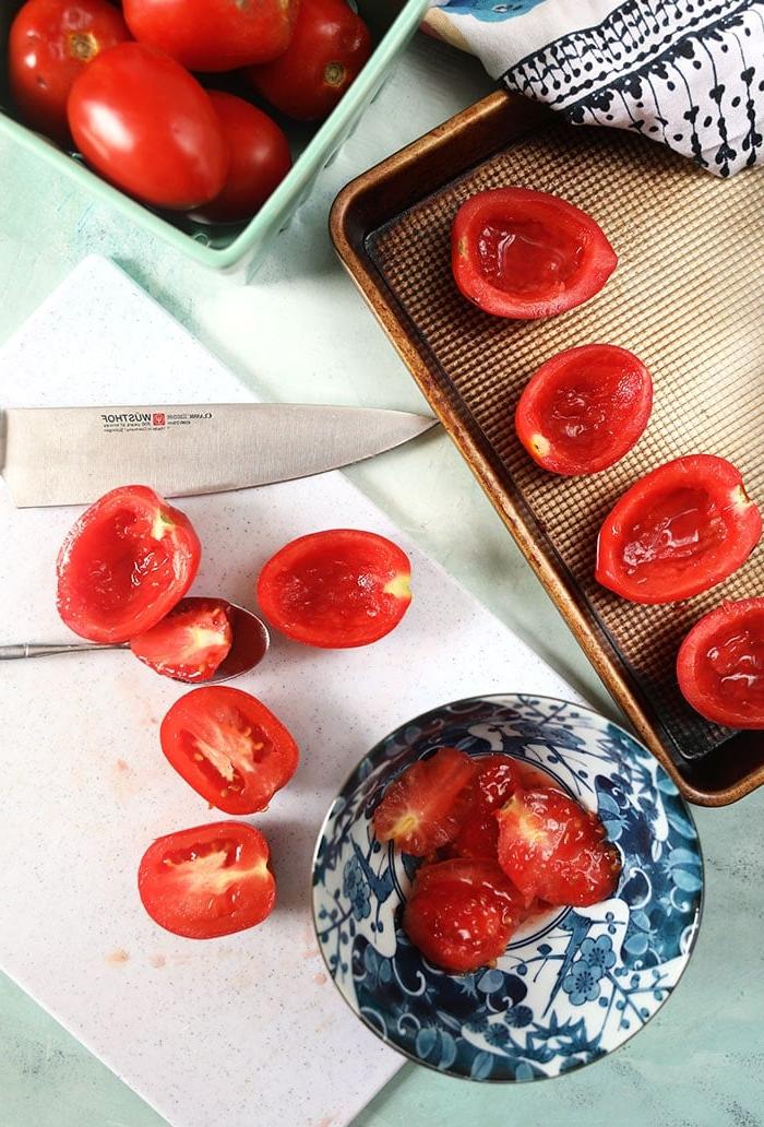 **Pomodori Arrostiti al Forno Facili** 4 Pomodori prugna tagliati a metà con i semi rimossi, pronti per essere arrostiti.