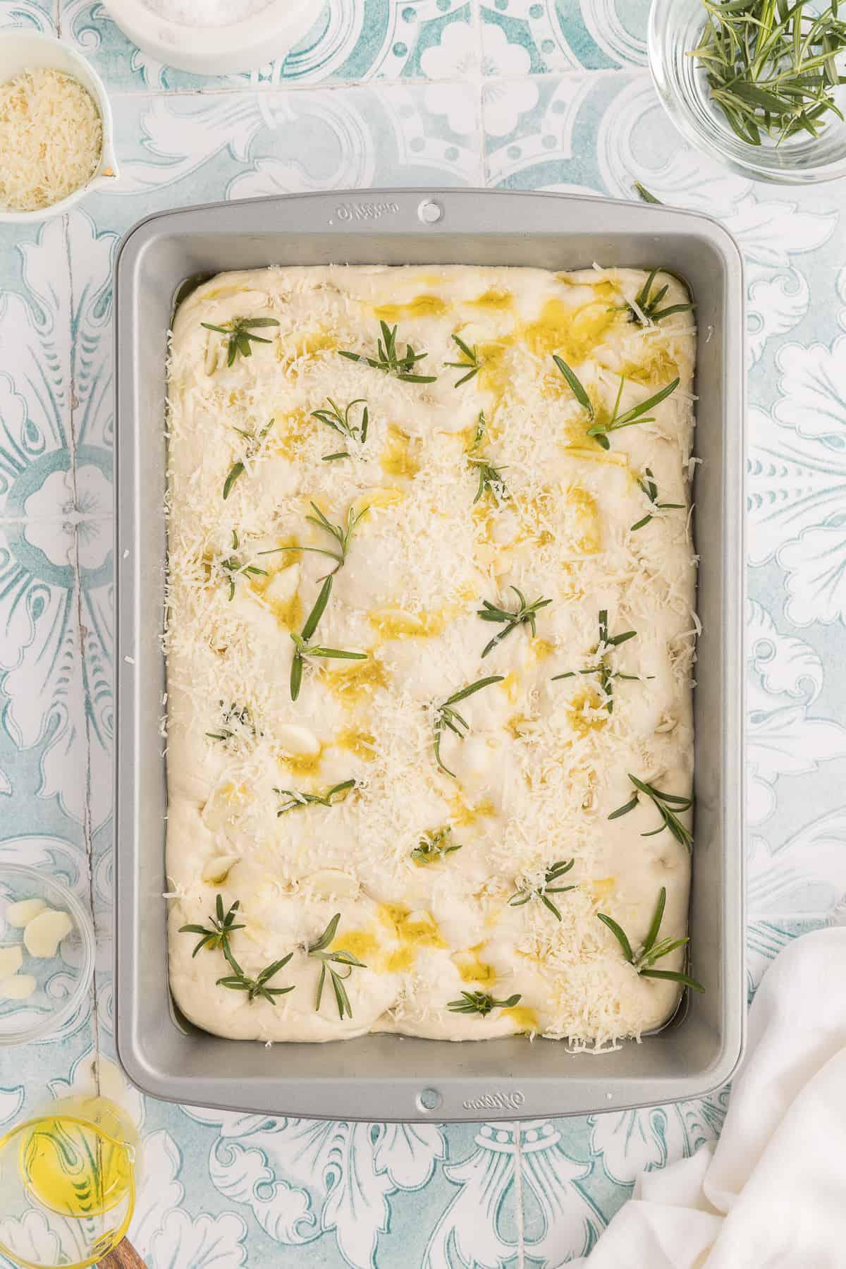 Focaccia all'Aglio e Rosmarino 4 Una teglia è riempita con focaccia non cotta.