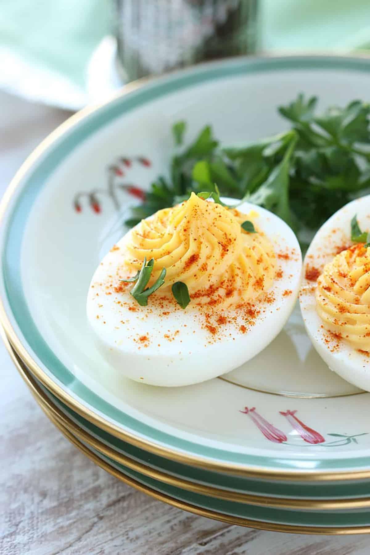 La migliore ricetta di uova ripiene di sempre 4 Uovo ripieno su un piatto con paprika e prezzemolo cosparsi sopra.