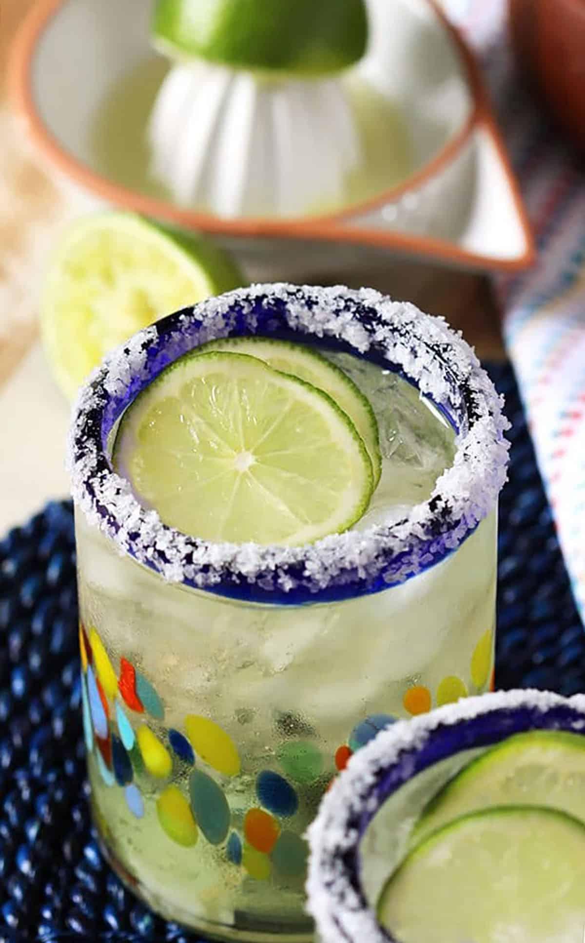 Margarita Classico 4 Margarita in un bicchiere con fette di lime e il bordo ricoperto di sale.