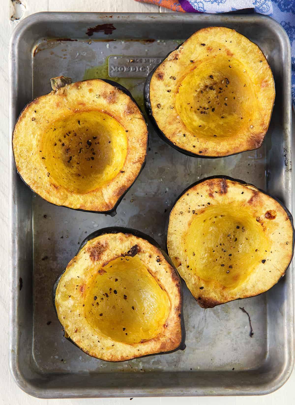 Come cucinare la Zucca Ghianda 4 Quattro metà di zucca sono posizionate su una teglia da forno.