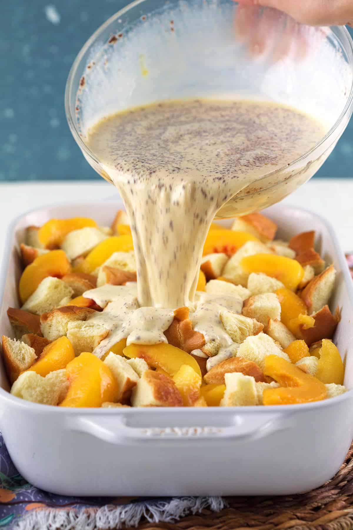 **Sformato di French Toast alle Pesche** 4 Un composto di uova viene versato sopra pesche e pane in una pirofila.