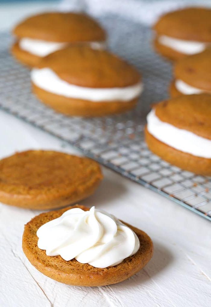 **Whoopie Pies alla Zucca con Ripieno al Mascarpone d'Acero** 5 Crema su un morbido biscotto alla zucca su sfondo bianco.