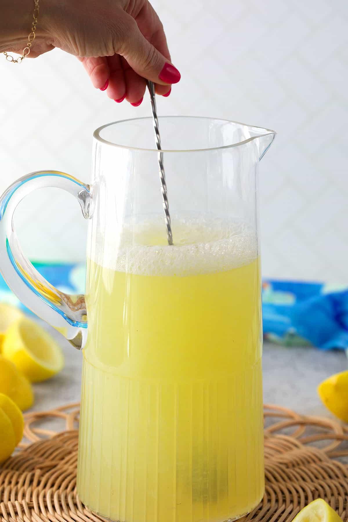 Ricetta della Limonata Fatta in Casa 5 Limonata mescolata in una caraffa di vetro.