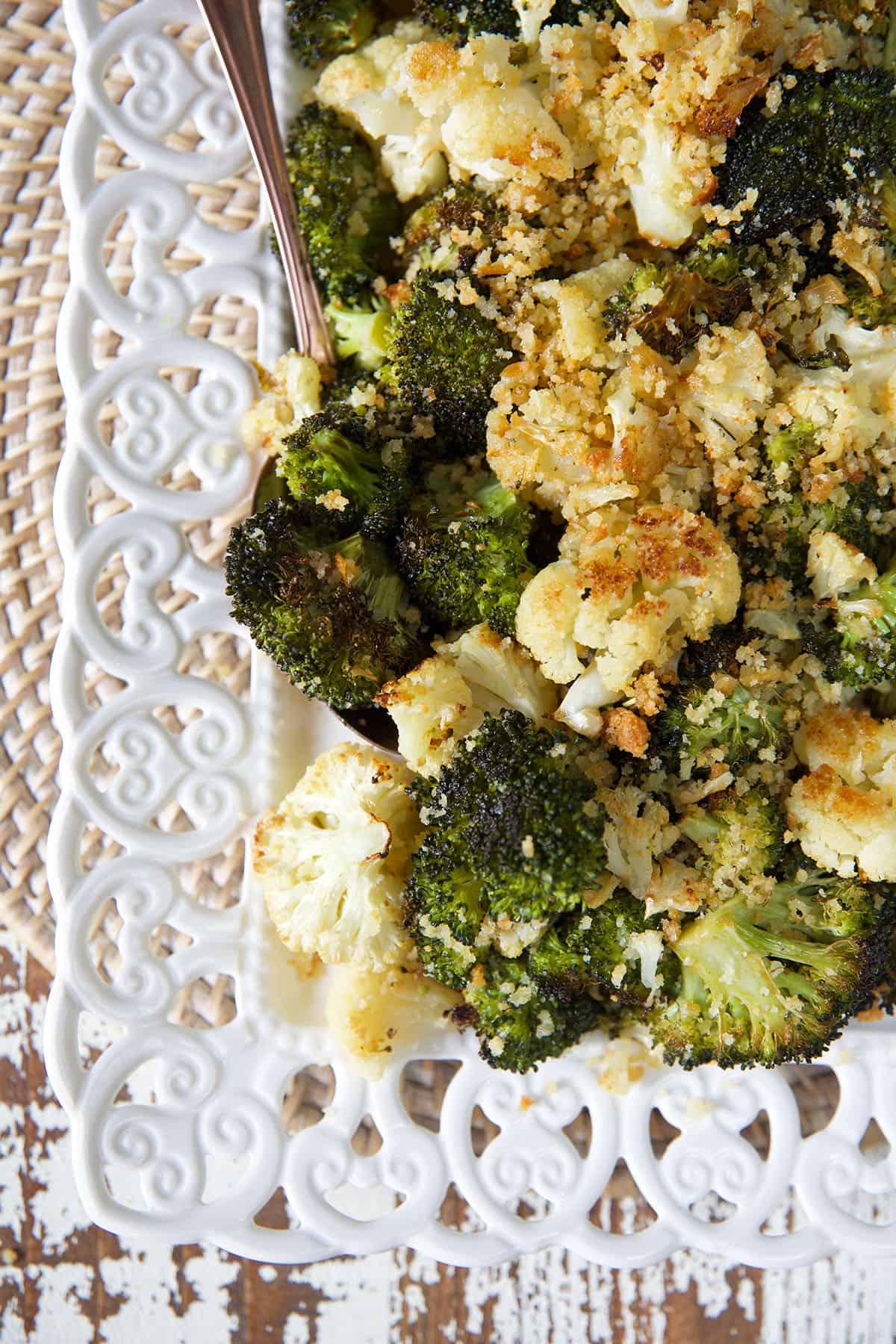 Facile Broccoli e Cavolfiore Arrostiti 5 L'angolo di un piatto bianco è riempito di verdure arrosto.
