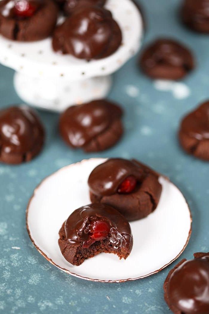 Biscotti al Cioccolato e Ciliegie con un morso su un piatto bianco.