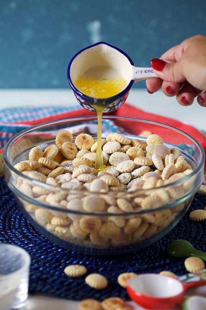 **Facile Crackers Gusto Ranch** 5 Burro versato sui crostini oyster in una ciotola di vetro.