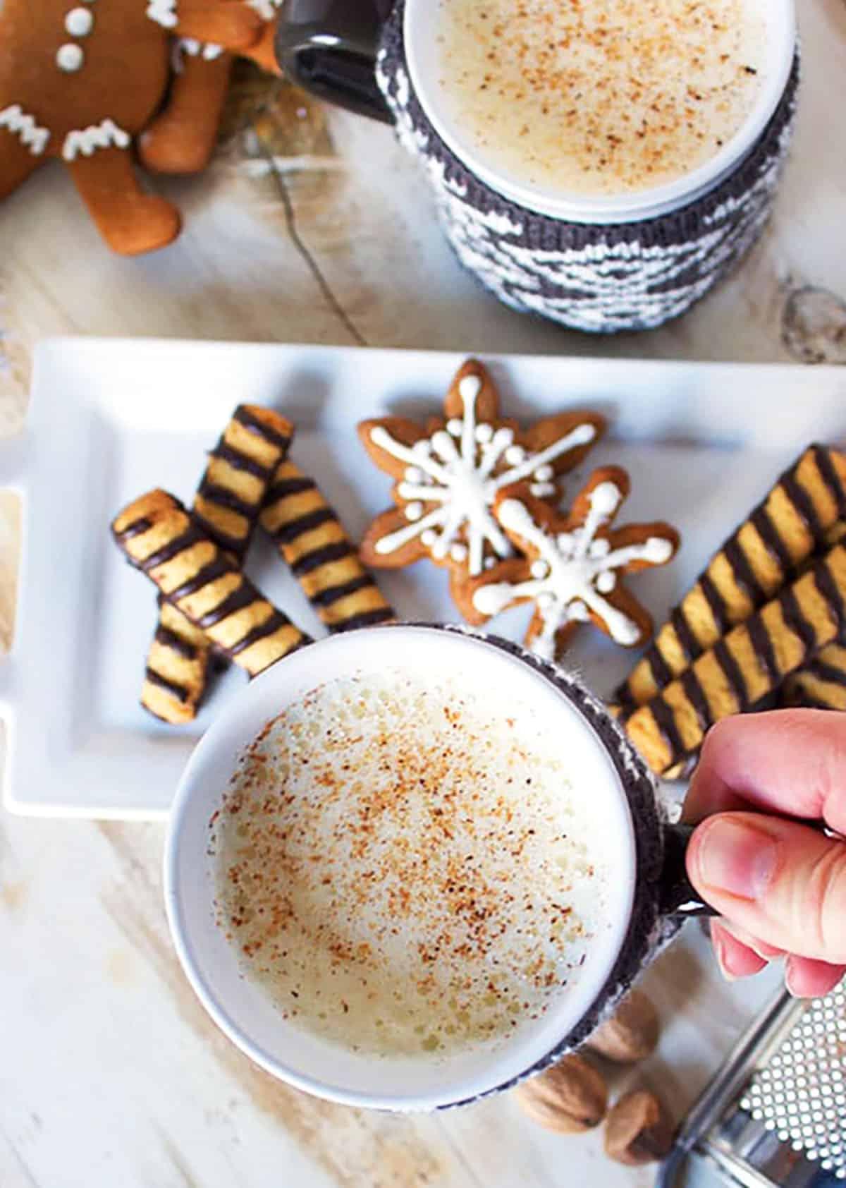 La Migliore Ricetta Fatta in Casa di Zabaione 5 Mano che tiene una tazza di eggnog.