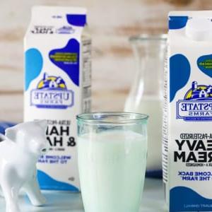 **Cos'è il Latte e Panna (e come prepararlo da zero!)** 6 Cartone di panna, bicchiere di latte e un cartone di half and half con una lattiera a forma di mucca bianca.