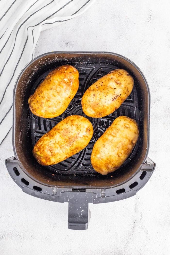 Patate al Forno Facili nella Friggitrice ad Aria 6 Patate condite con olio e spezie, pronte per la friggitrice ad aria.