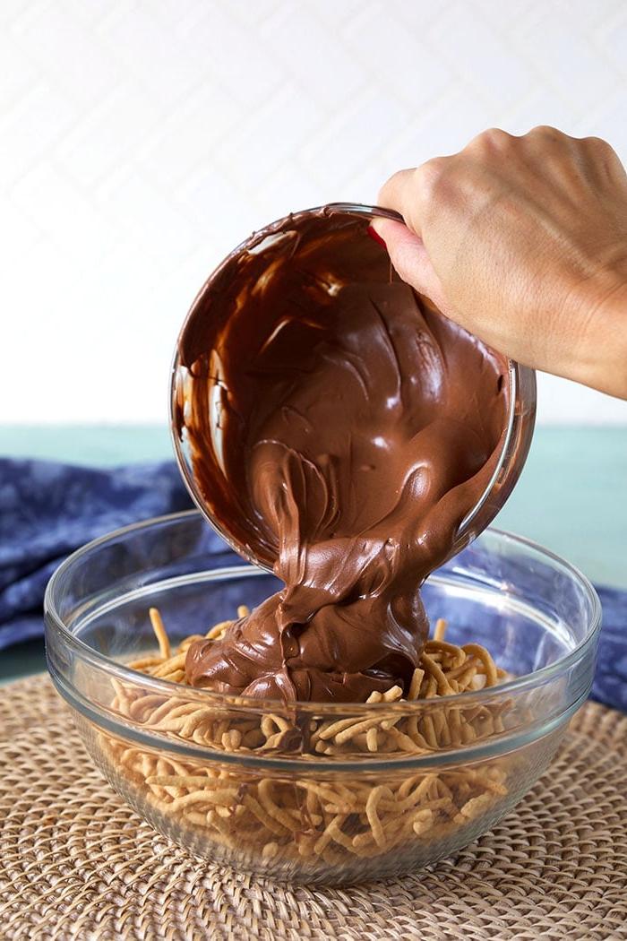 Biscotti Pagliaio Senza Cottura 6 Cioccolato fuso versato su noodles chow mein in una ciotola di vetro.