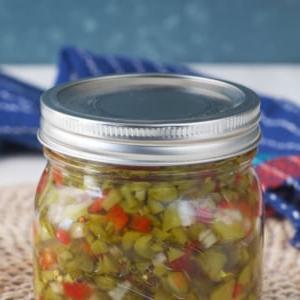 Un barattolo di salsa di cetriolini è posizionato su una tovaglietta.