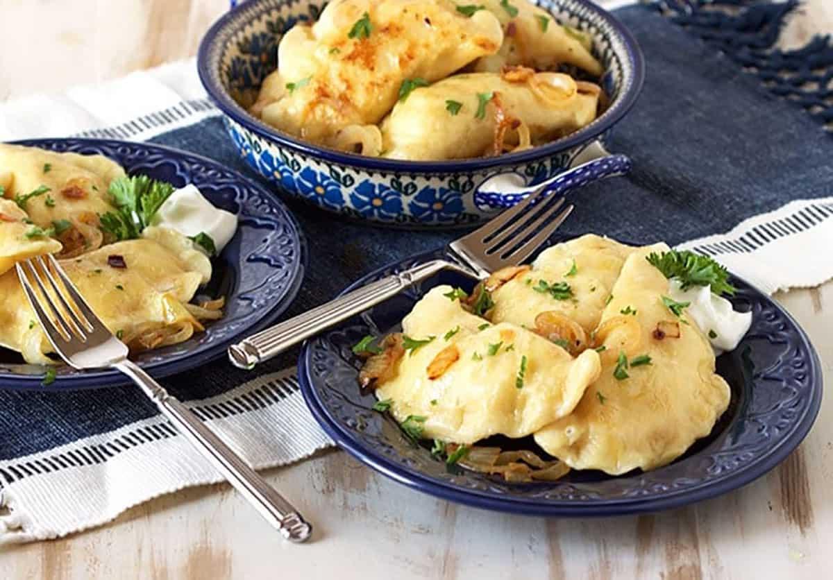 La migliore ricetta di pierogi di patate 6 Pierogi di patate su piatti blu.