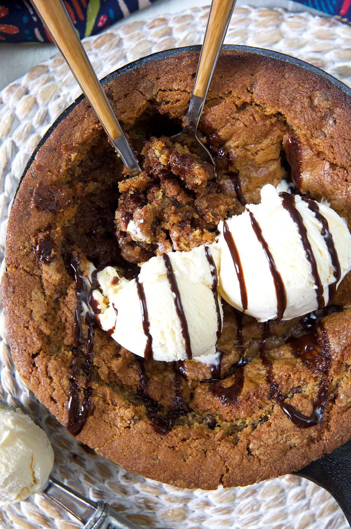 Biscotto-Pizza Fatto in Casa con Gocce di Cioccolato 6 Due palline di gelato alla vaniglia sono poste su un pizookie caldo.