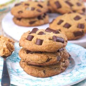 Biscotti alle Gocce di Cioccolato e Burro di Arachidi 6 Biscotti impilati in un piccolo mucchio su un piatto rotondo.