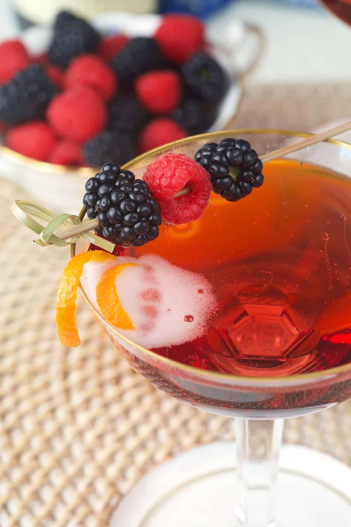 Classico Kir Royale 6 Bicchiere di Kir Royale guarnito con frutti di bosco e una scorza d'arancia.