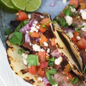 Semplici Tacos di Carne Asada 6 Due tacos di carne asada sono guarniti con coriandolo fresco, pico de gallo e formaggio cojita.