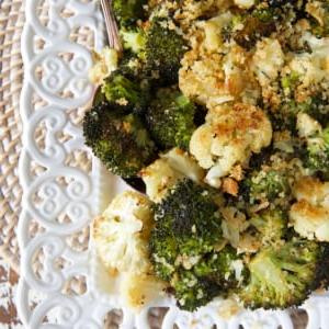 Facile Broccoli e Cavolfiore Arrostiti 6 L'angolo di un piatto bianco è riempito di verdure arrosto.