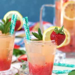 Limonata alle Fragole Fatta in Casa 7 Limonata alla fragola in un bicchiere con guarnizione di fragola e cannuccia