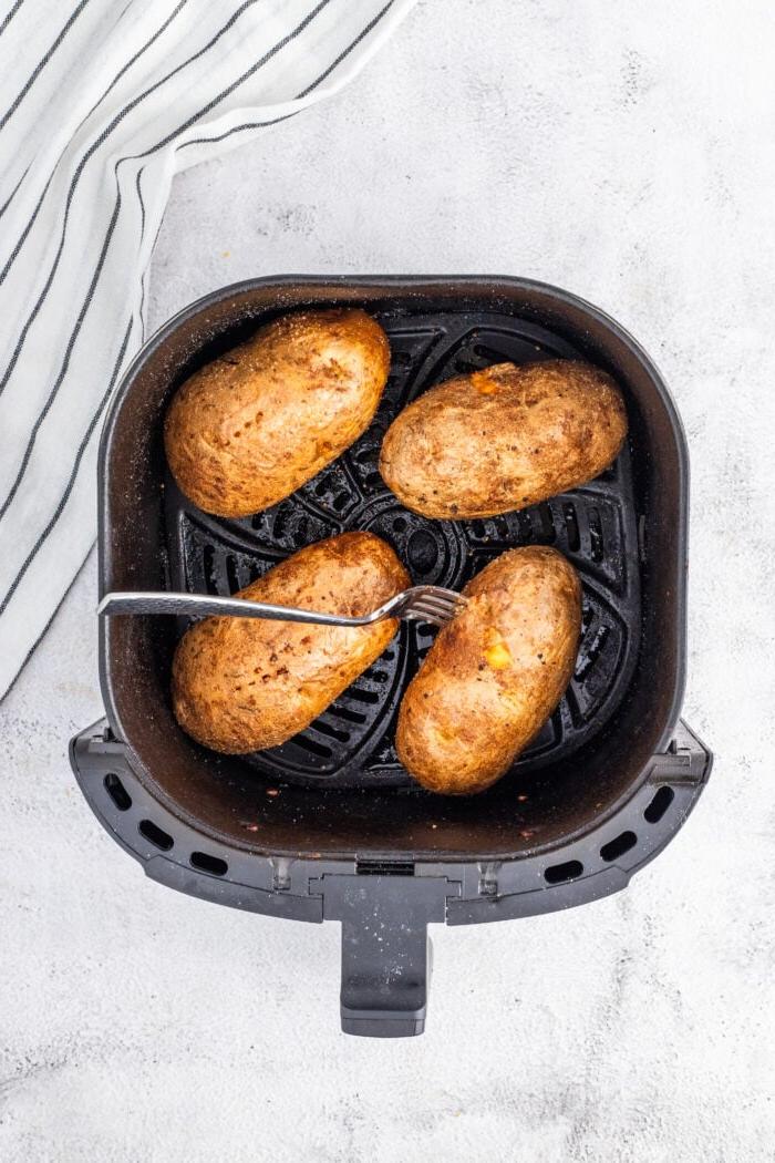 Patate al Forno Facili nella Friggitrice ad Aria 7 Quattro patate cotte nel cestello di una friggitrice ad aria.