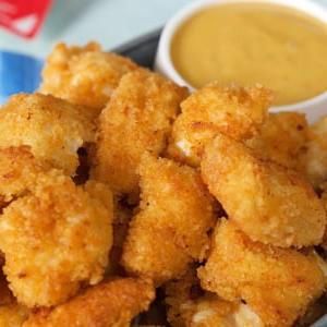 **Nuggets Imitazione Chick-fil-A** 7 Nuggets di pollo in una ciotola d'acciaio con salsa per intingere.
