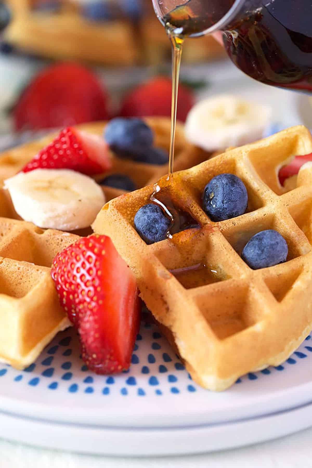 Il Migliore Waffle Belga Casalingo 8 Waffle belga su un piatto bianco con frutta fresca.