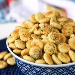 **Facile Crackers Gusto Ranch** 9 Crostini oyster al gusto ranch in una ciotola bianca e blu su uno sfondo blu.