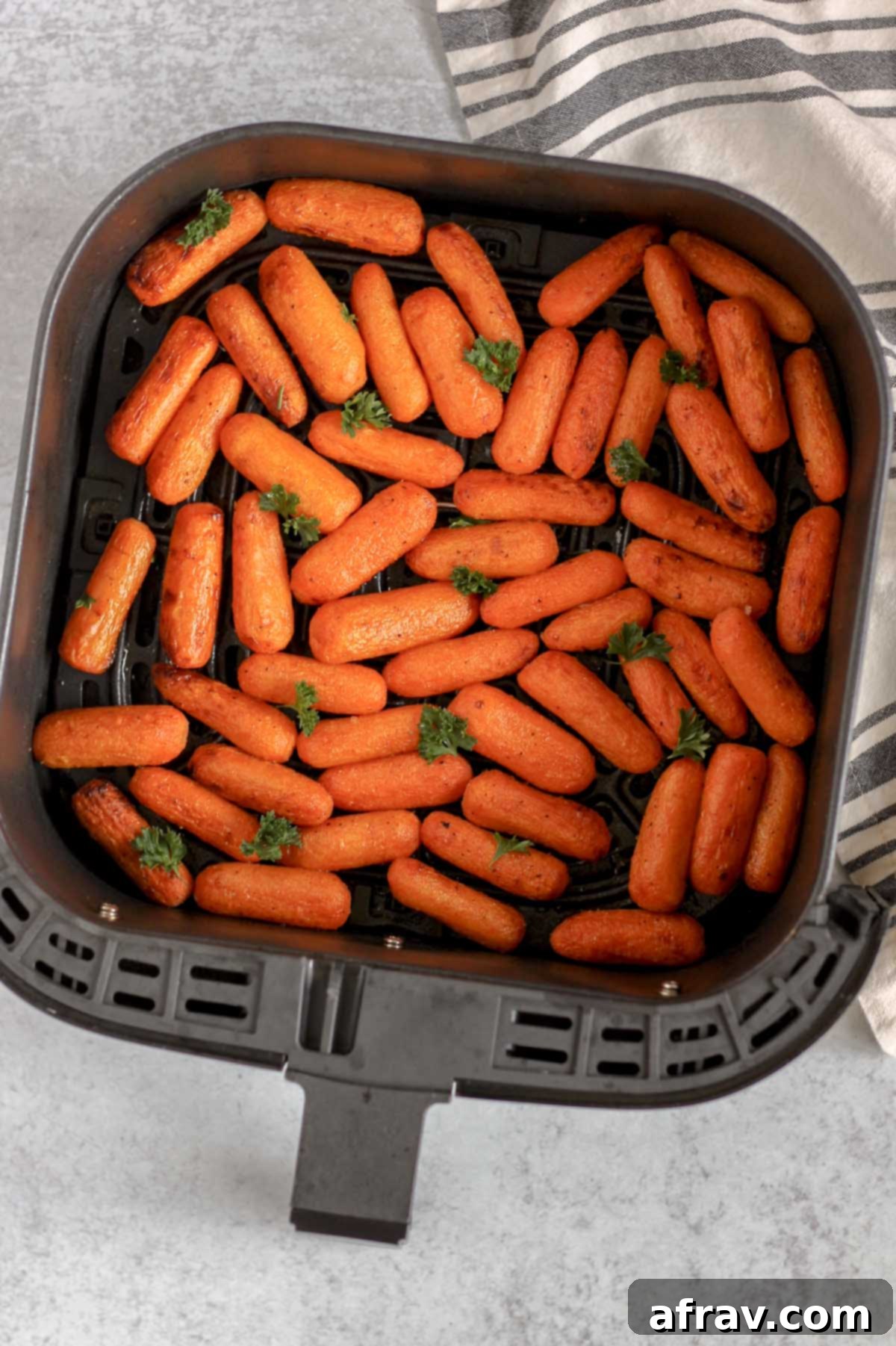 Air fried roasted baby carrots in an air fryer basket.